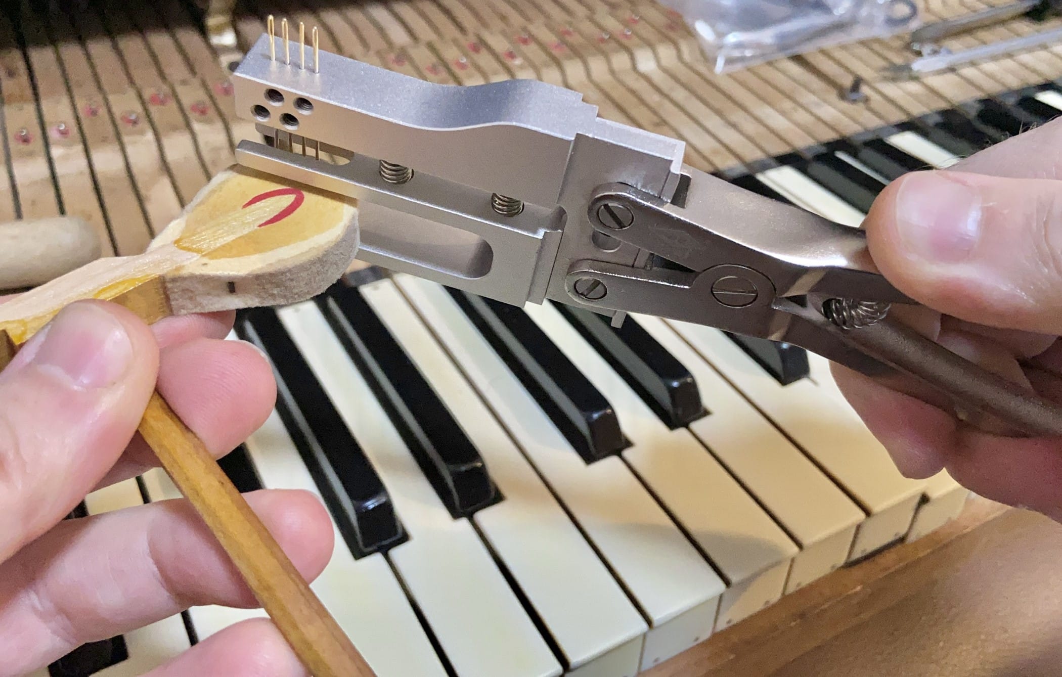 Using a special plier with attached needles to prick the felt surrounding the hammer head.